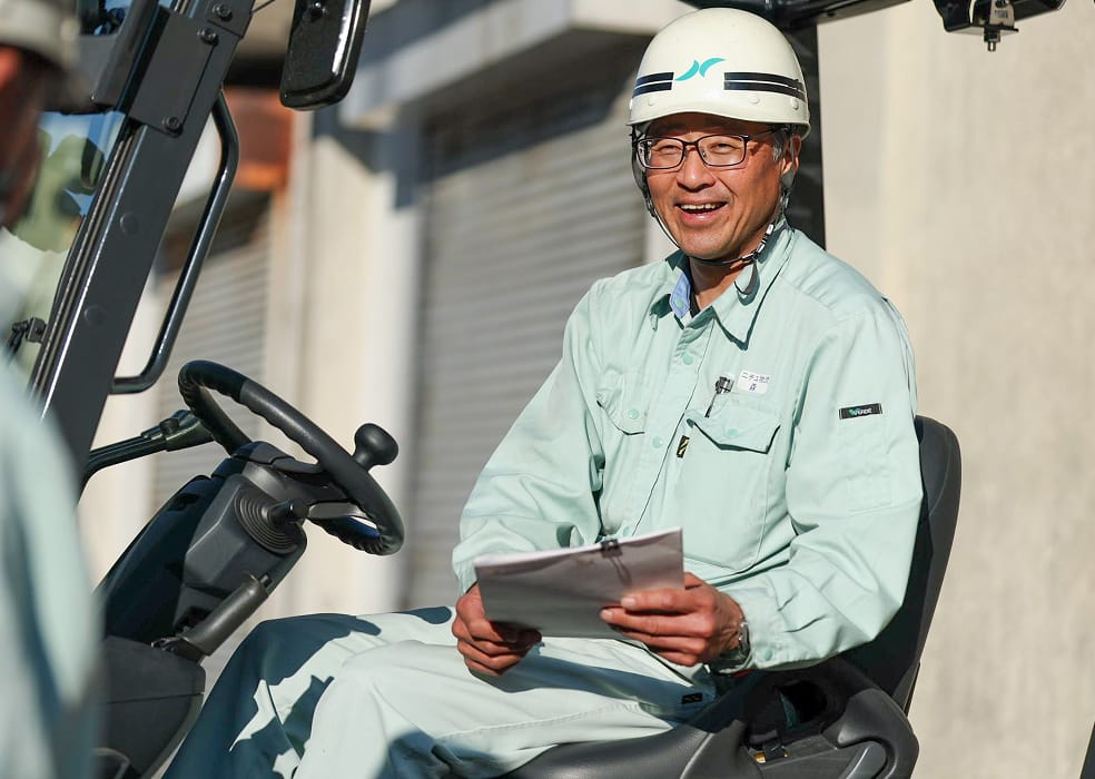 フォークリフトに乗る作業スタッフの写真