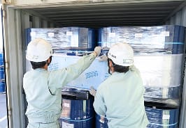 コンテナに荷物を積む作業スタッフの写真