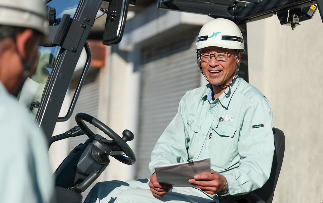 フォークリフトの座席から仲間と話すY.Kさん