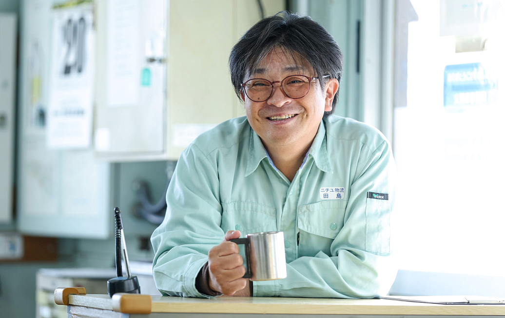 マグカップを手にして笑顔のD.Tさん